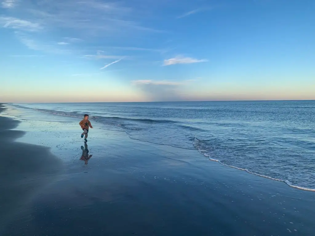 A boy walking on a beach in Hilton Head, SC.