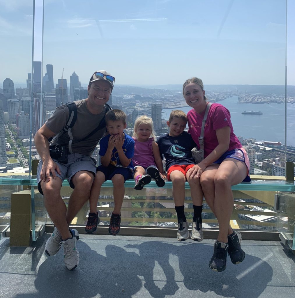 A family posing on a bench overlooking a city.