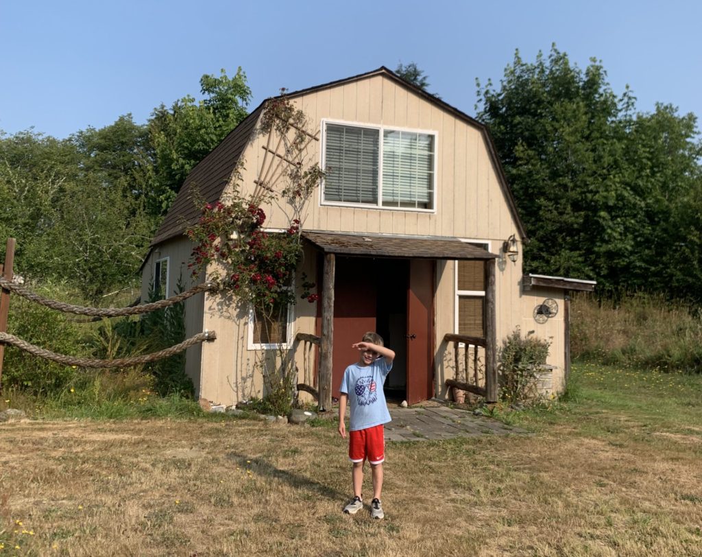 A boy embarks on an adventure in front of a small house.