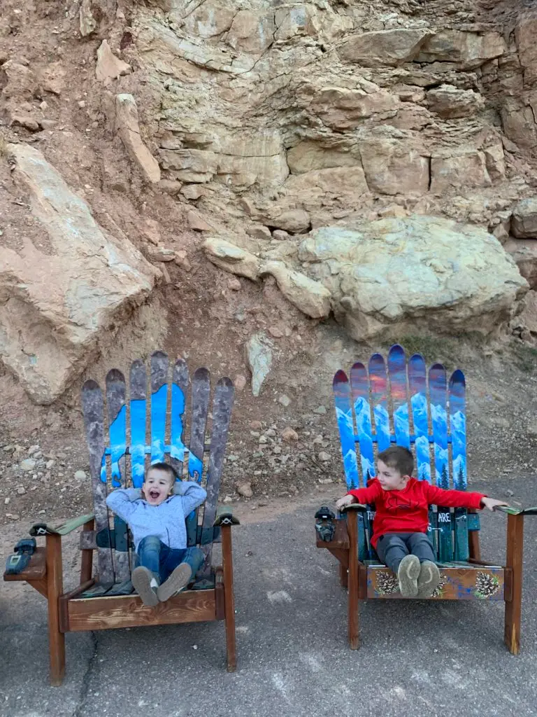 A group of children sitting on chairs in front of a rocky area.  Colorado Springs with Kids is perfect destination.