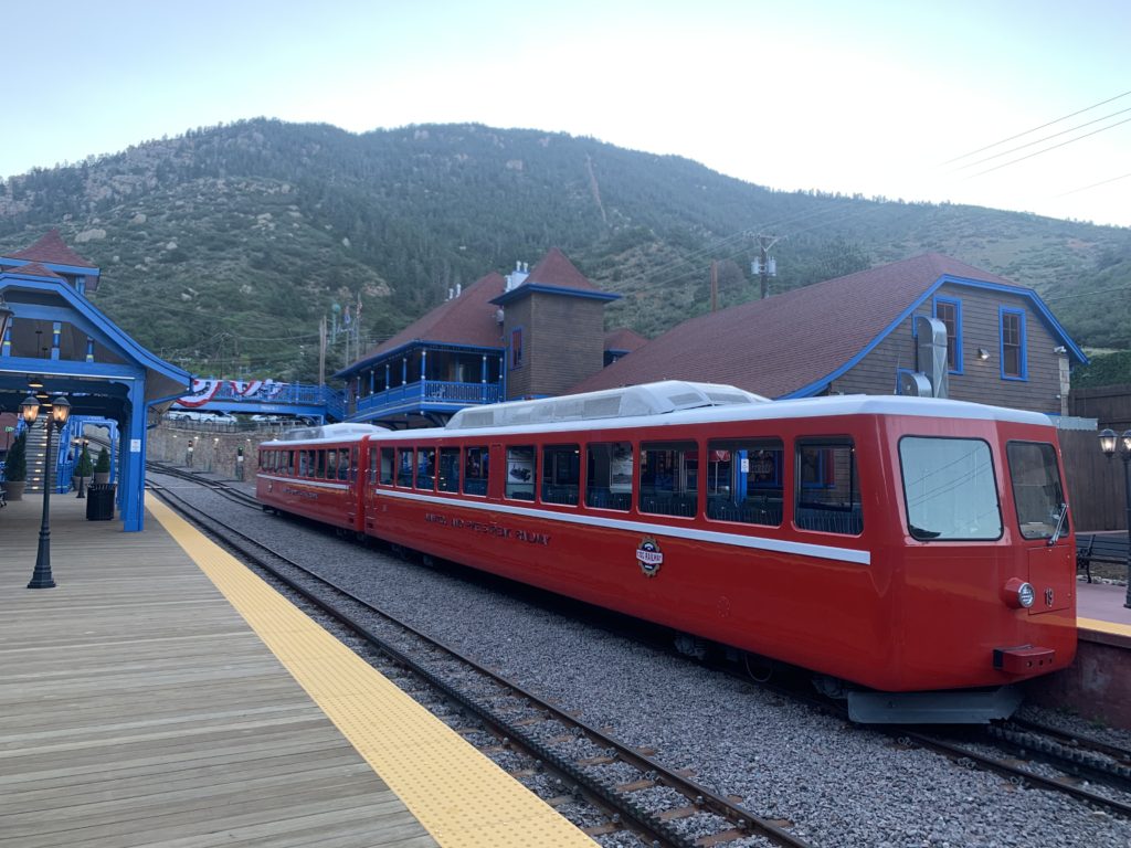 A red train pulling into a train station.