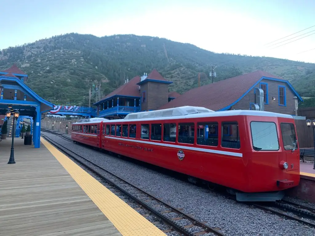 A red train pulling into a train station.