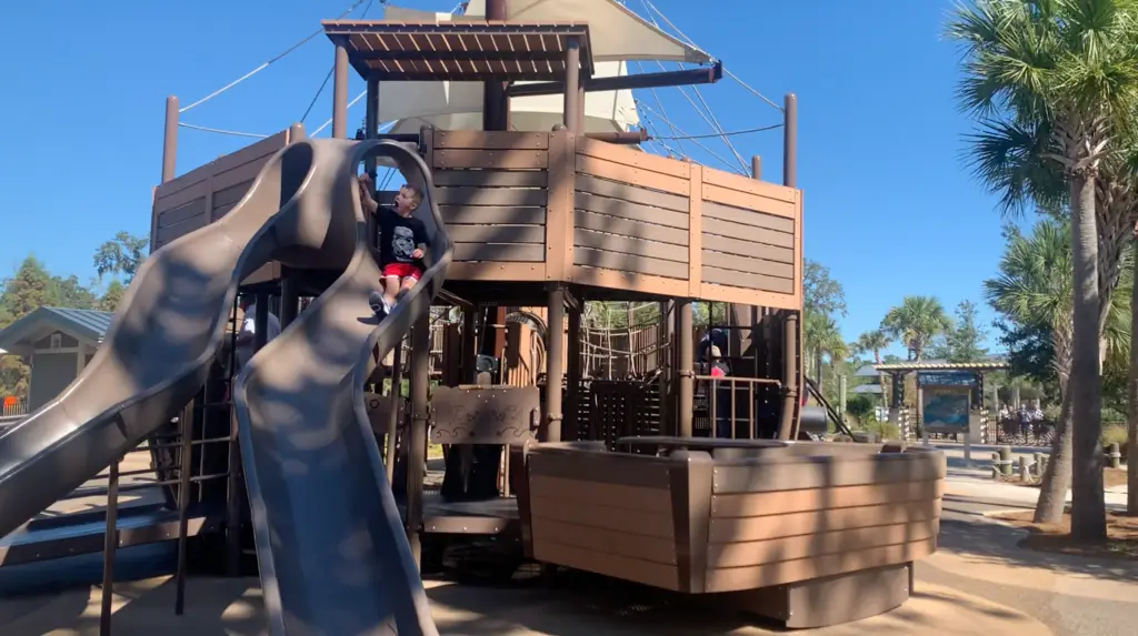 A wooden playground with a slide and a pirate ship on a Hilton Head family vacation.