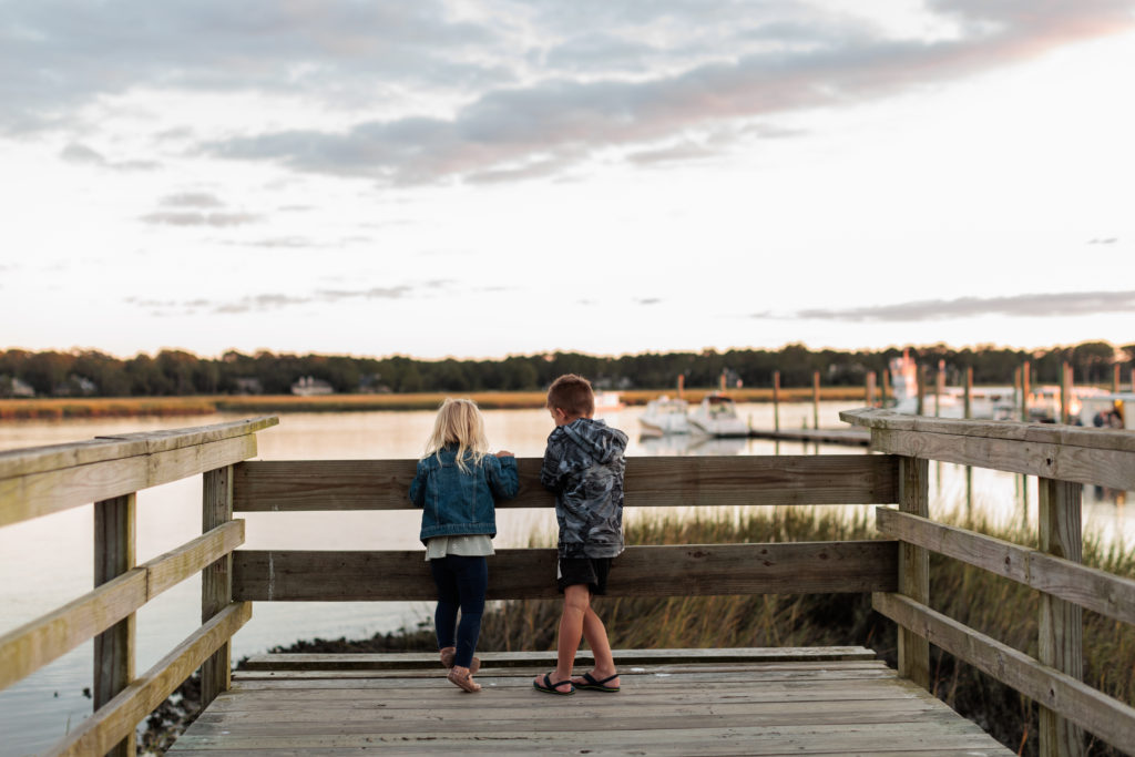 Two children standing on a dock looking at the water on a Hilton Head family vacation.