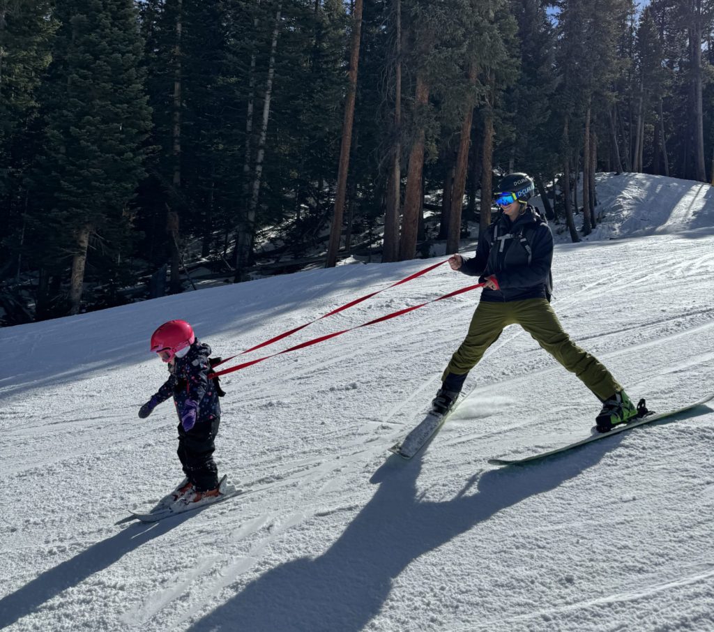 A man and a child skiing down a snowy slope at Keystone, a best ski resort for kids.