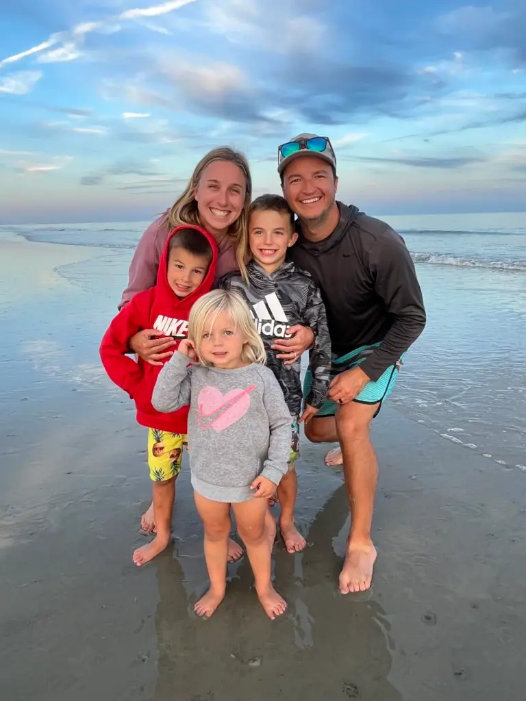 A family posing for a photo on the beach for a Hilton Head family vacation.