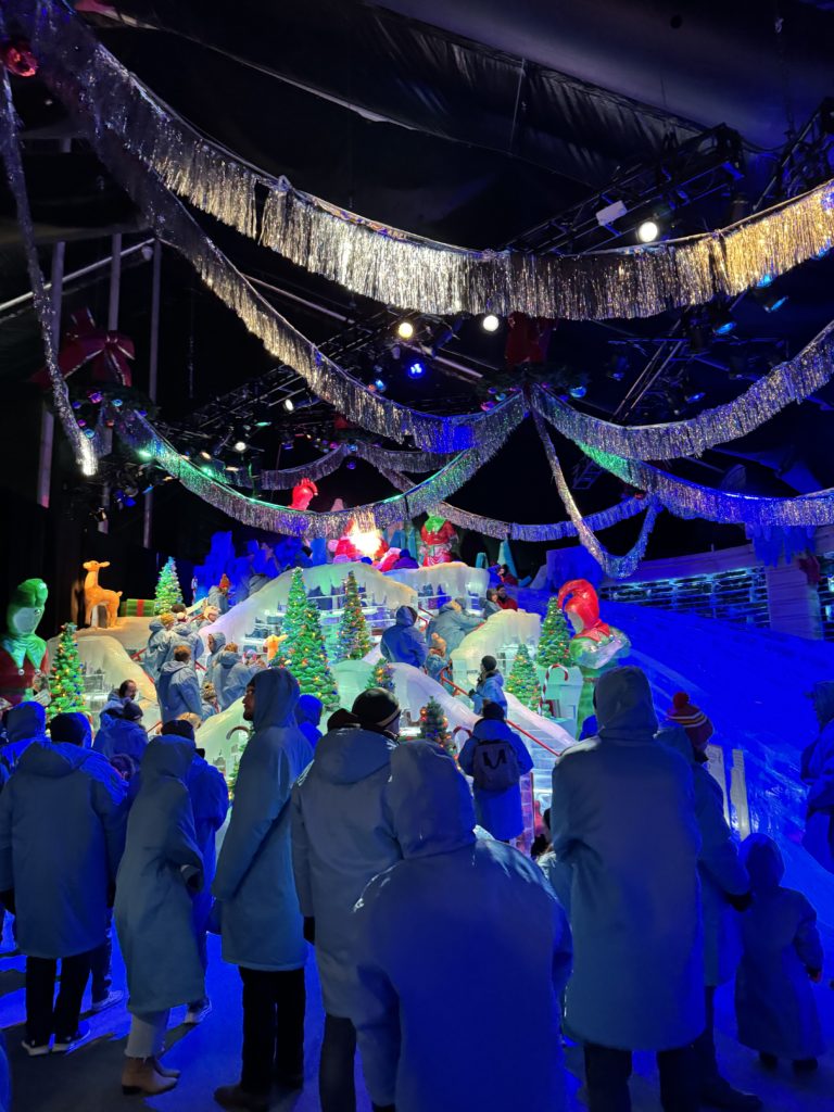 A group of people are standing in front of a snow globe.