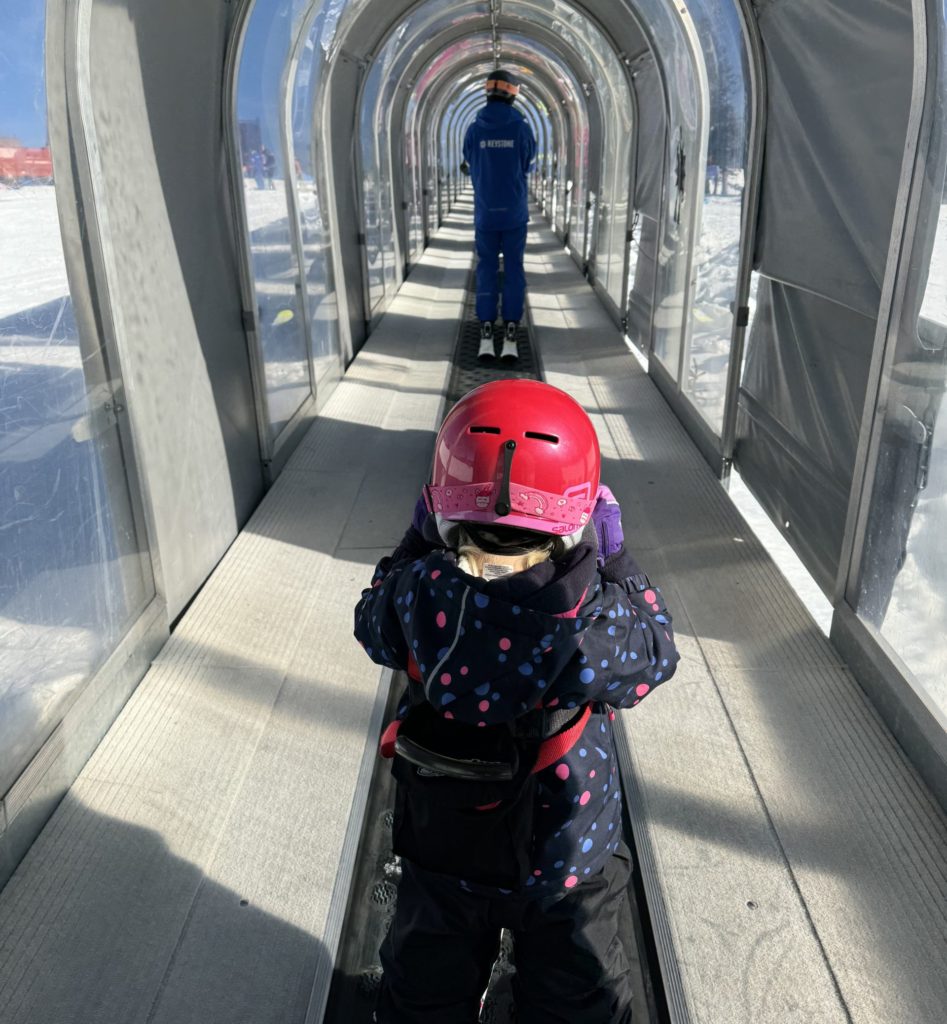 A child wearing a helmet on a ski lift.