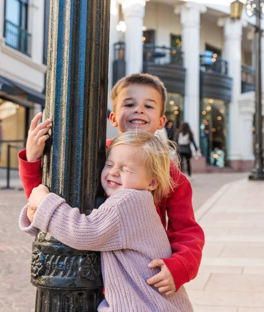 Two children hugging a sign pole in beverly hills. Beverly Hills With Kids.