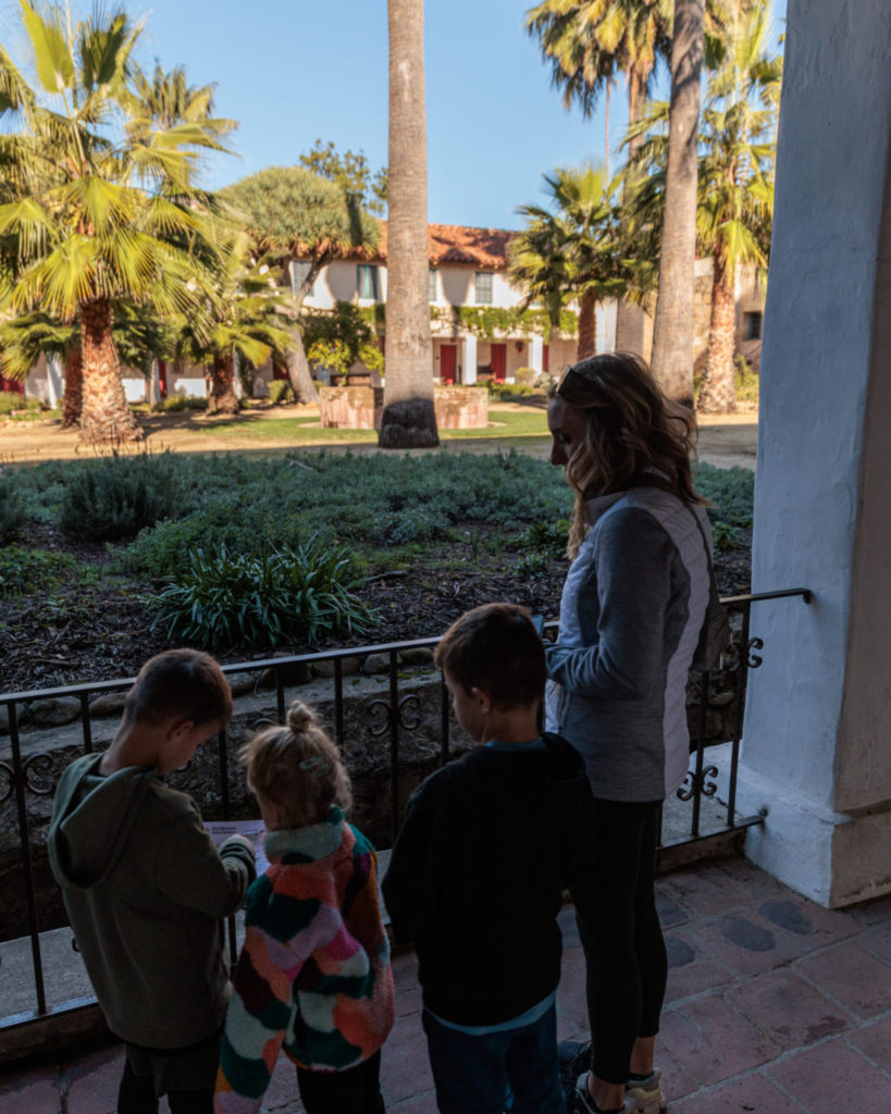 A group of children standing on a balcony. Old Mission Santa Barbara with kids.