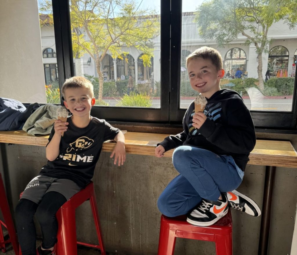 Two boys sitting on stools eating ice cream. State Street with kids.