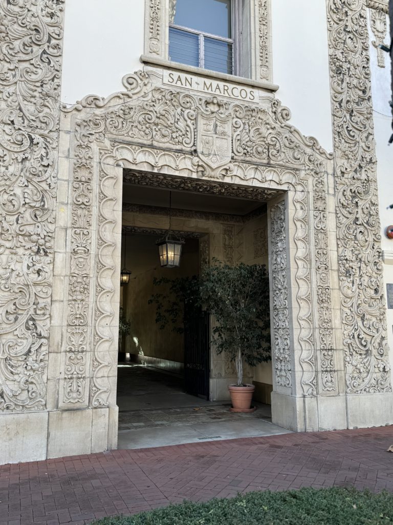 The entrance to a building with ornate carvings.  State Street with kids.