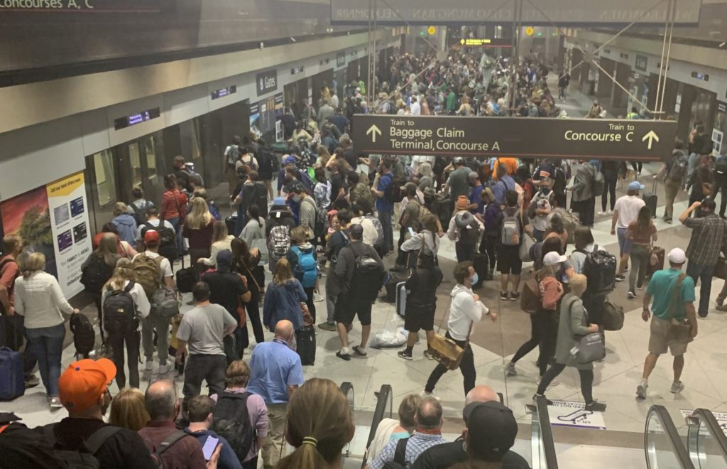 A large crowd of people in an airport. A reason for is clear worth it for families