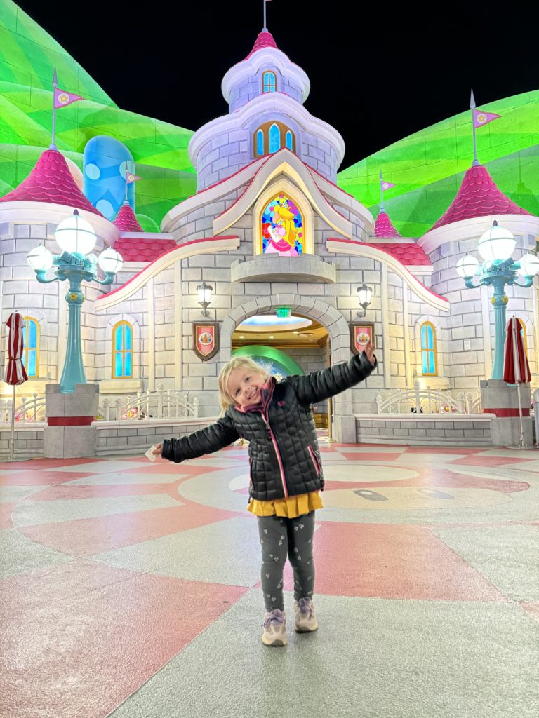 A girl standing in front of a large building for our Super Nintendo World review