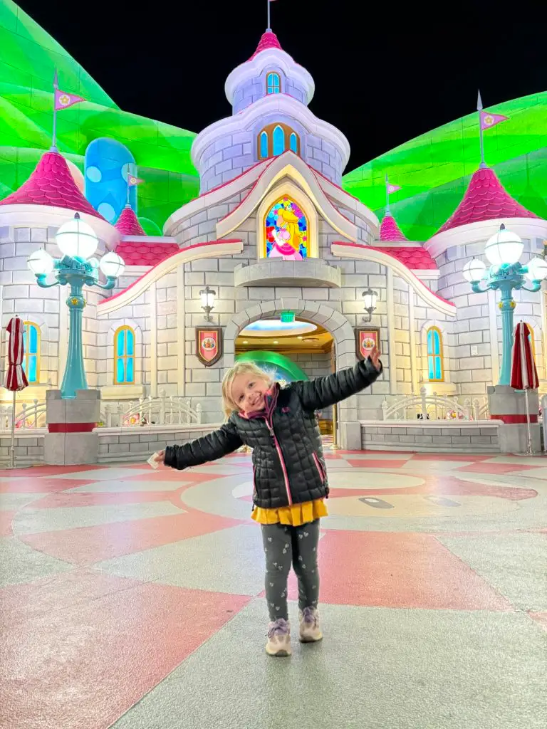 A girl standing in front of a large building for our Super Nintendo World review