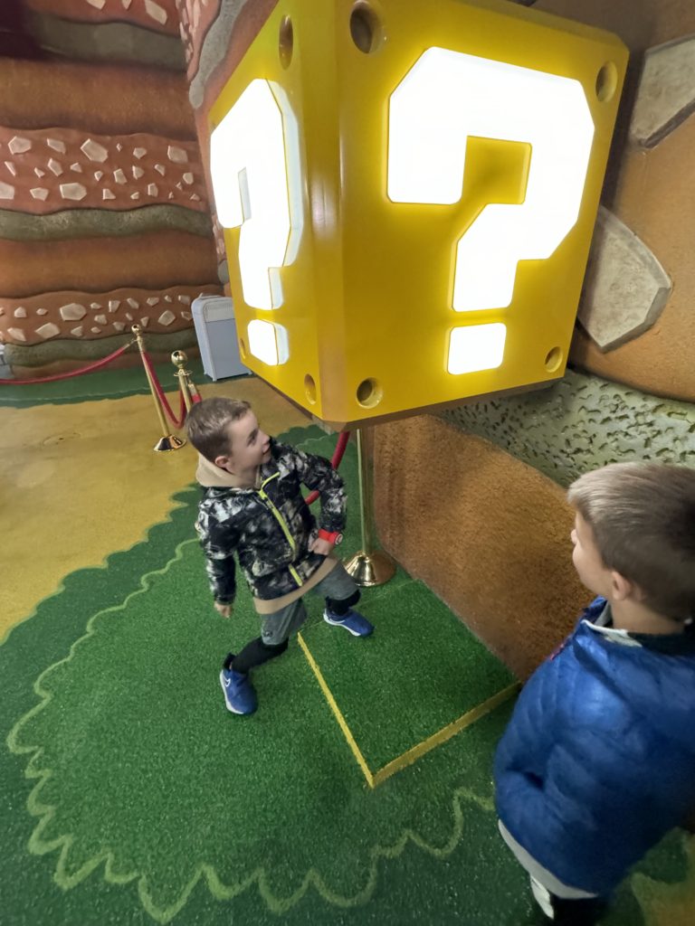 Two boys standing in front of a question mark for our Super Nintendo World review