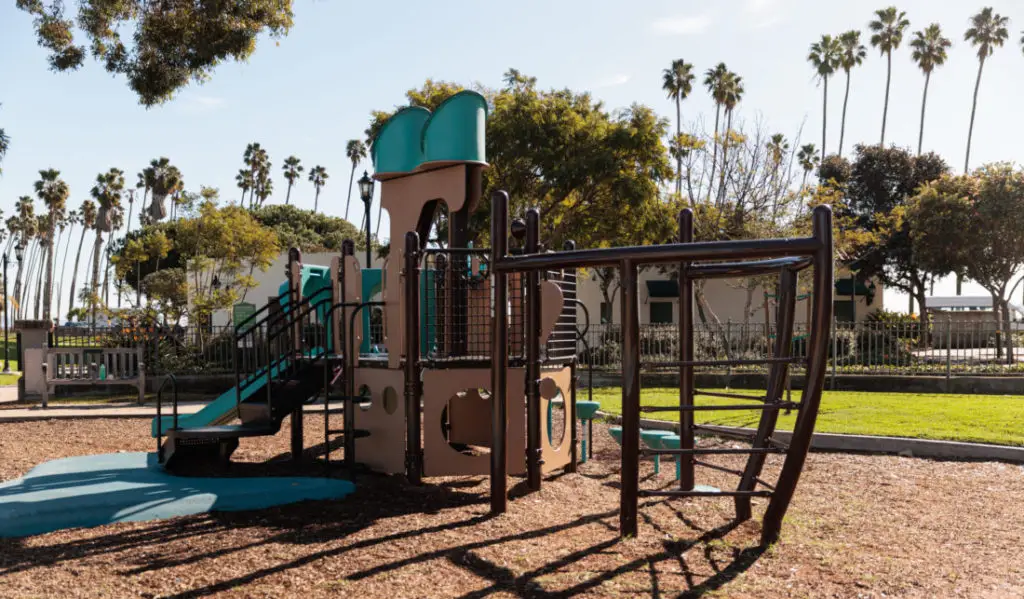 A playground with a slide and swings. Santa Barbara Playgrounds