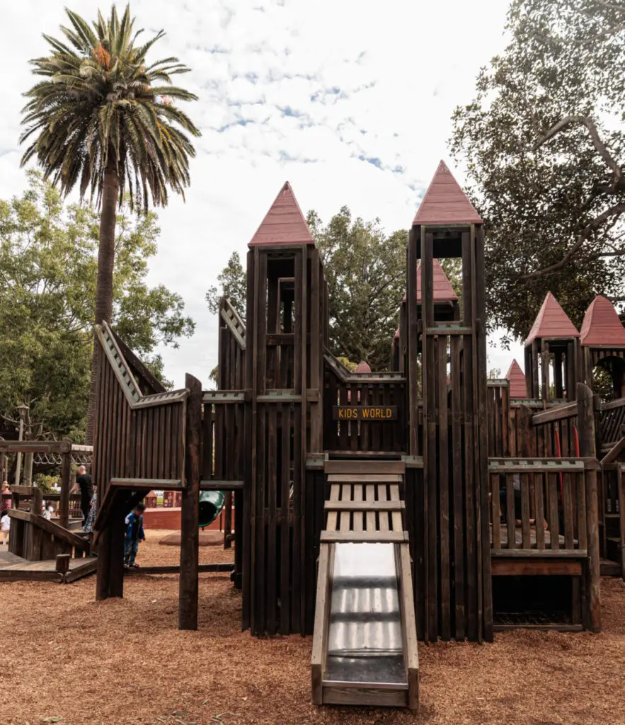 A wooden play structure in a park. Santa Barbara Playgrounds.