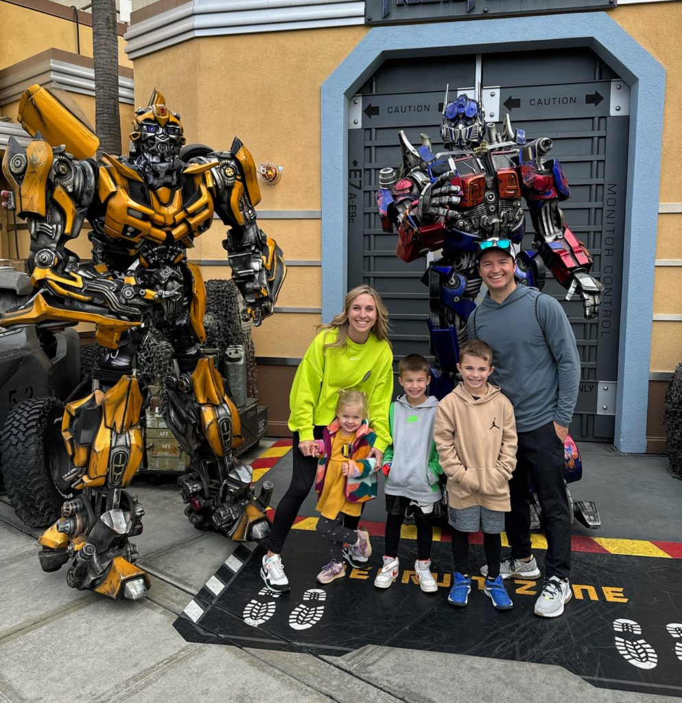 A family posing in front of Bumblebee and Meagtron transformers characters. Universal Studios Hollywood with Kids