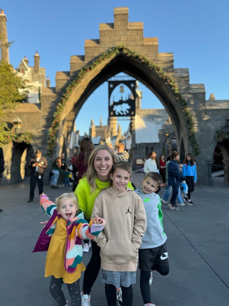 A family poses in front of hogwarts castle.  Universal Studios Hollywood with Kids