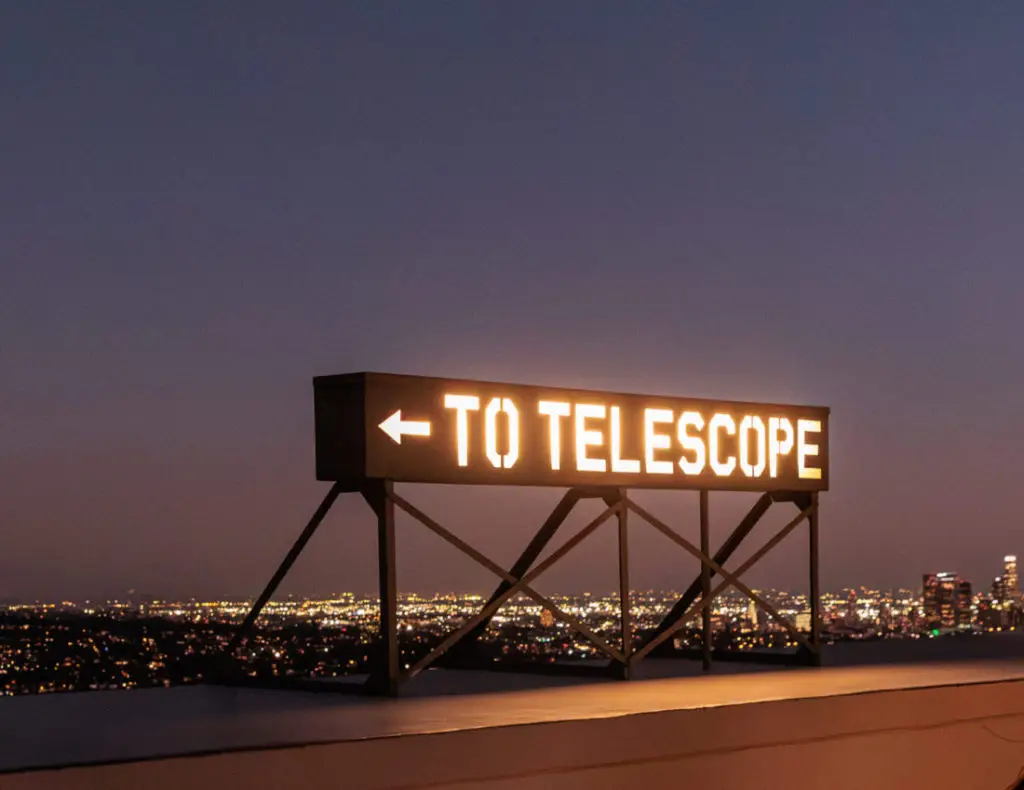 A sign that says to telescope. Griffith Observatory with kids