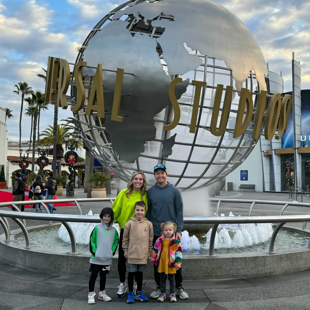 A family posing in front of the universal studios sign. Universal Studios Hollywood with Kids