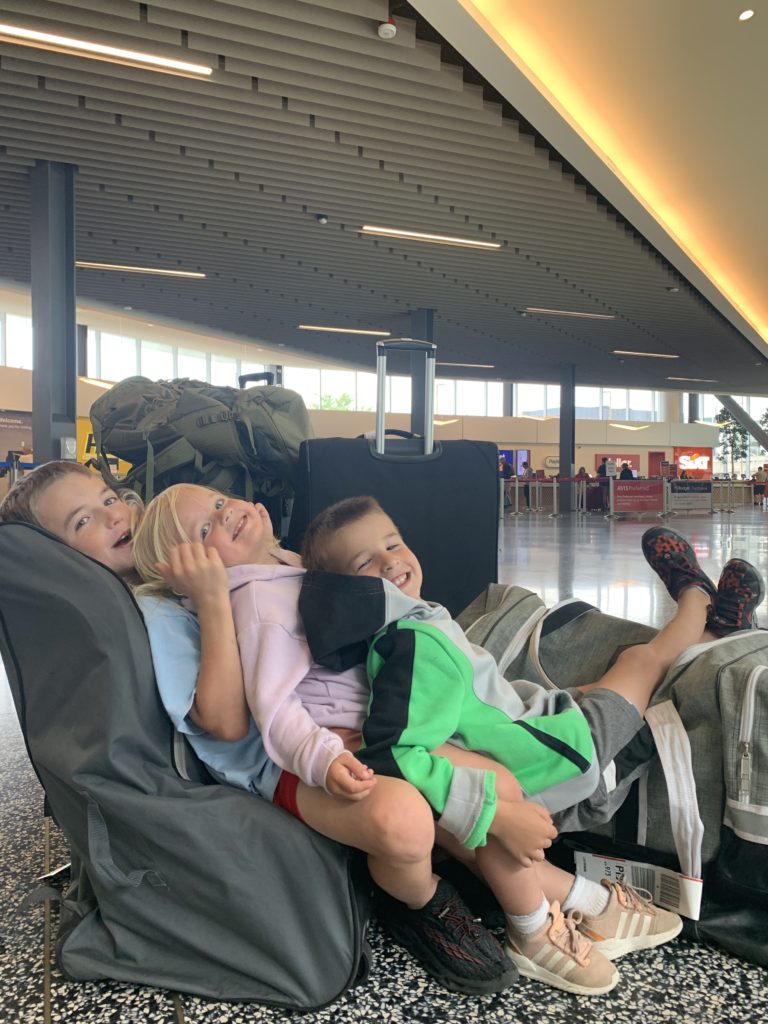 A family of children traveling in an airport.