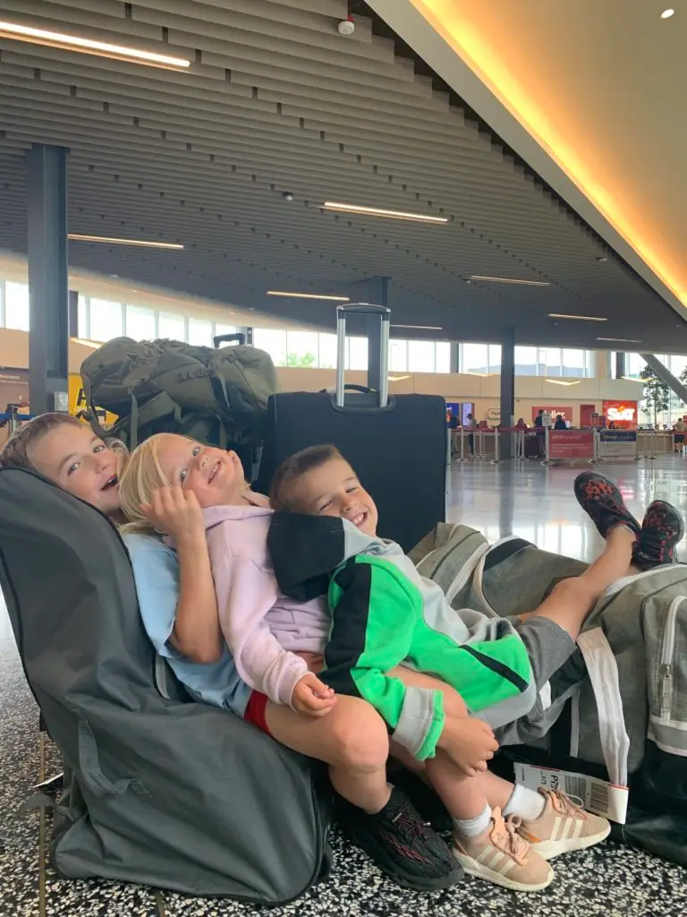 A family of children traveling in an airport.