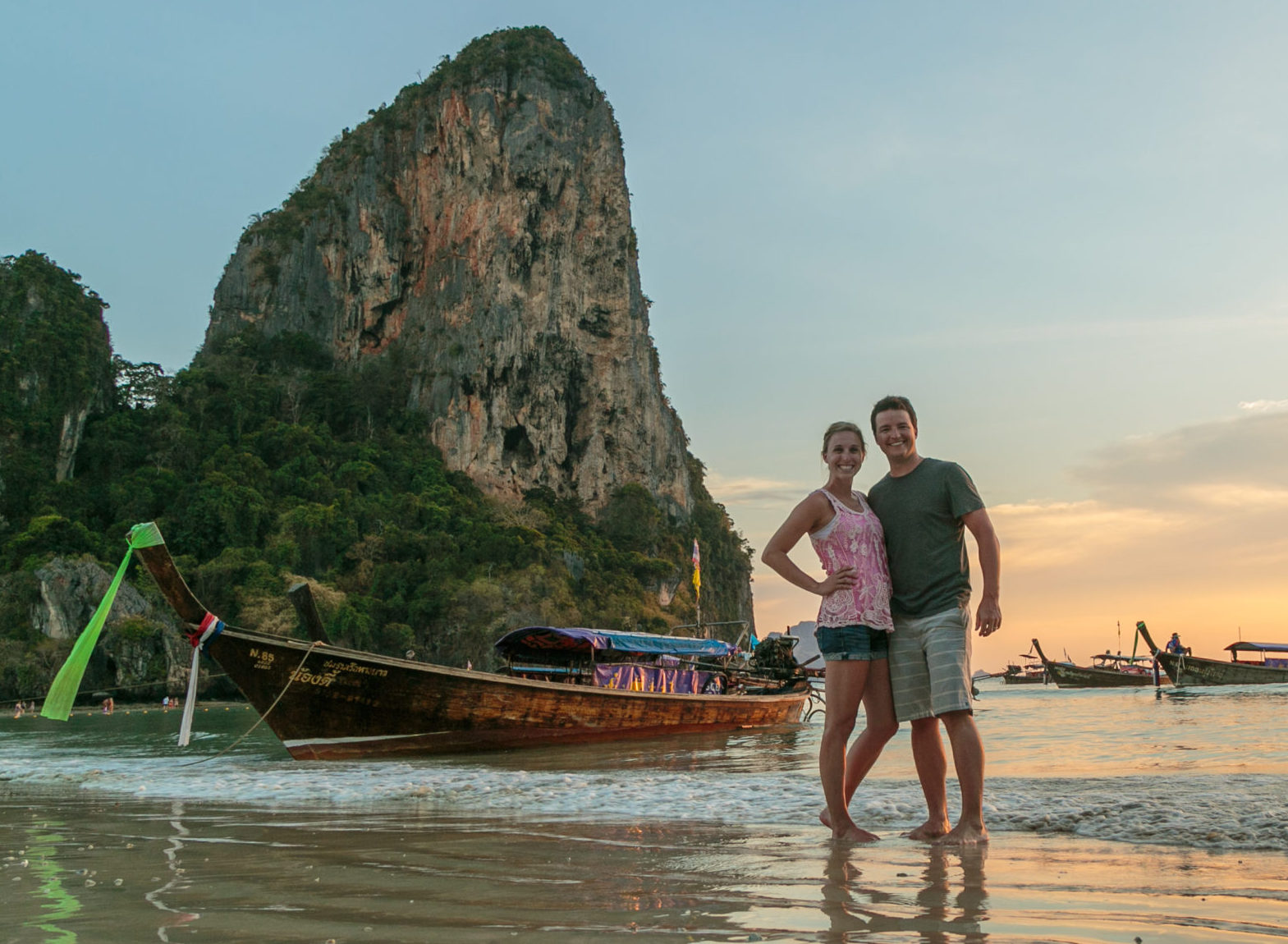 A couple enjoying an adventurous beach excursion next to a boat.