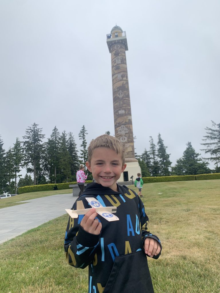 A young boy on a family adventure in front of a clock tower.