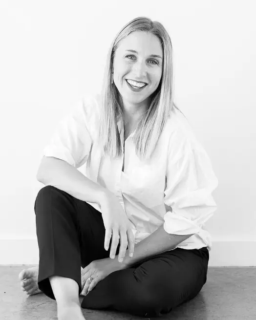 A black and white photo of a woman sitting on the floor during a travel adventure.