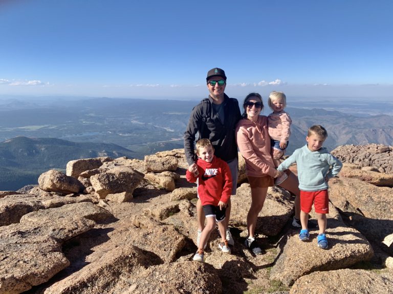 A family posing on top of a mountain.