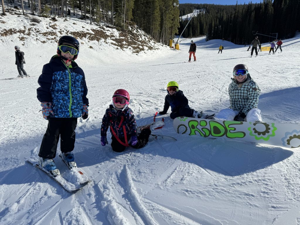 A group of kids posing with their snowboards.