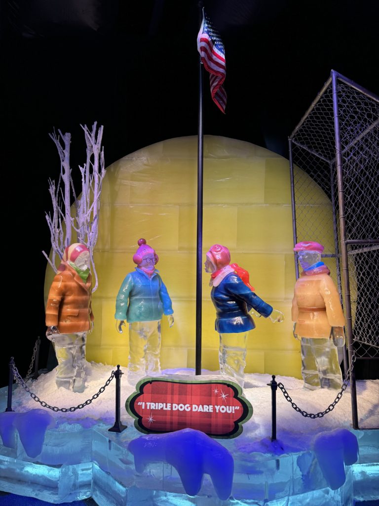 A group of people standing in front of a display of ice sculptures.