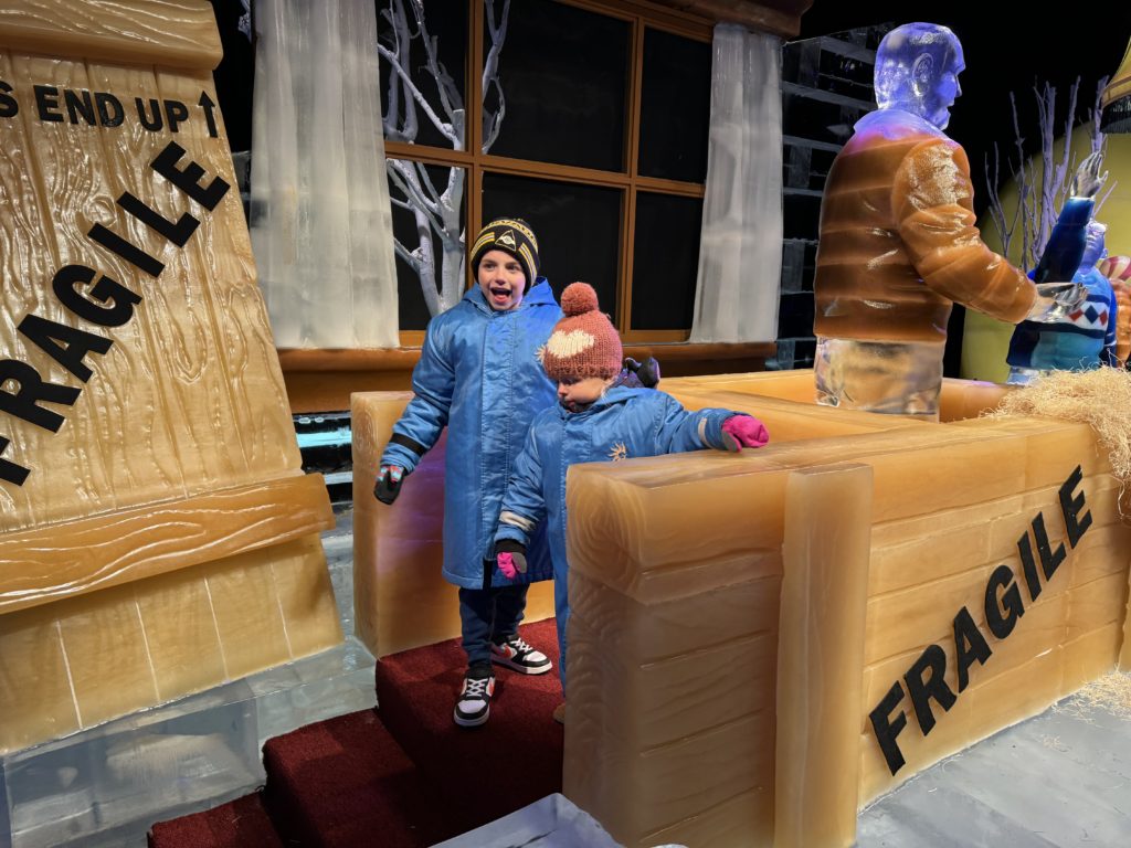 A man and a woman standing in front of an ice sculpture.