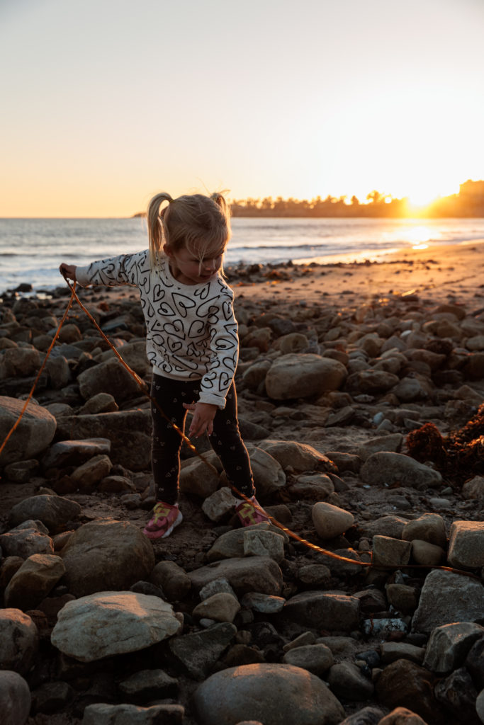 A little girl playing with a kite on a beach. Beaches in Santa Barbara With Kids