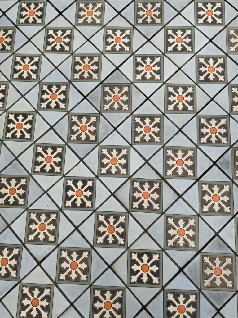 A tile floor with blue and orange designs. State Street with kids.