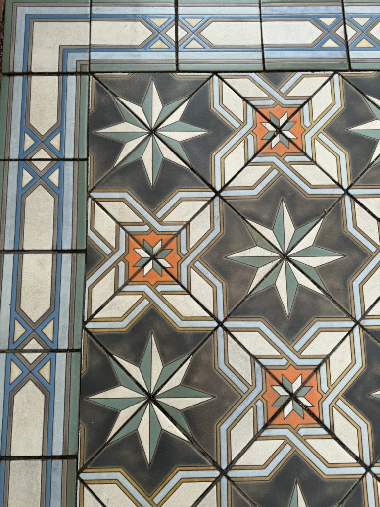 A tiled floor with an orange and blue design. State Street with kids.