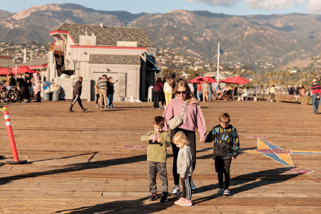 A group of people walking on a wooden boardwalk.