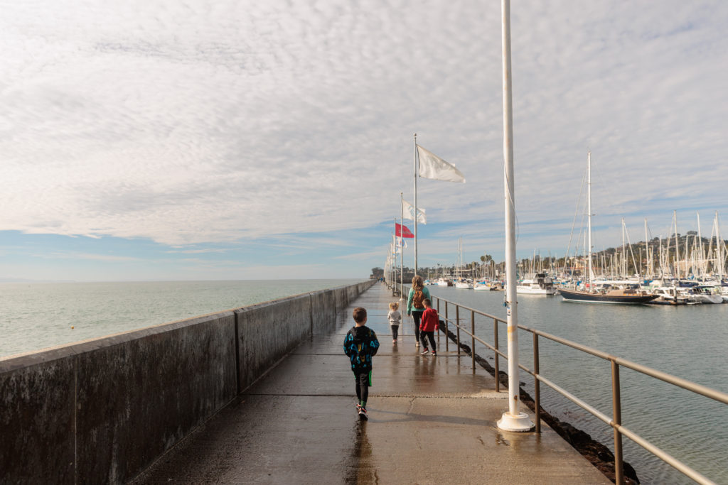 A group of people walking on a pier.