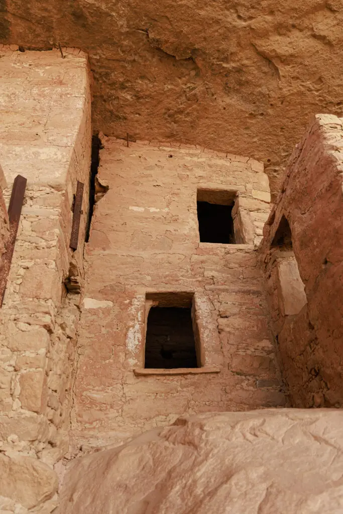 Exploring the ancient stone cliff dwellings with rectangular windows, built into a rock face, provides a fascinating glimpse into historical architecture—an adventure perfect for discovering Mesa Verde with kids.